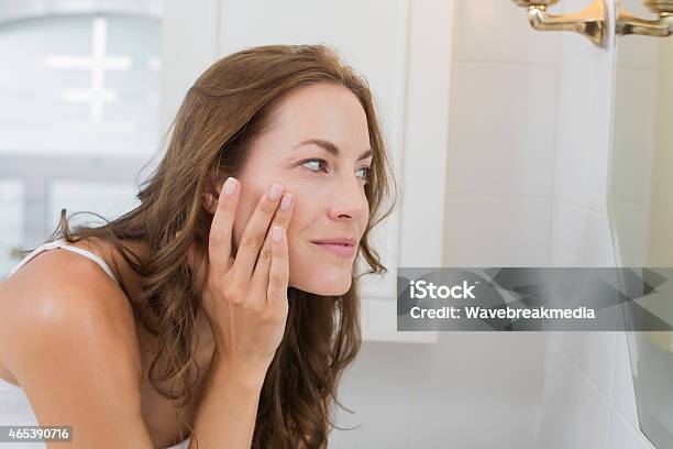 Side View Of A Beautiful Young Woman Examining Her Face Stock Photo - Download Image Now