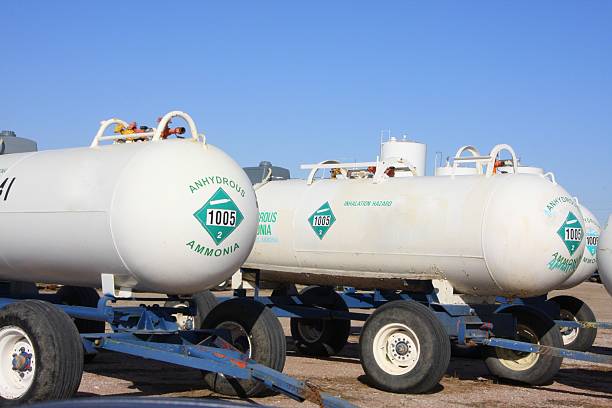 Anhydrous Ammonia Tanks are Ready to Roll These anhydrous tanks filled with nitrogen fertilizer at a farmers' cooperative in western Iowa are ready to head to the field to fertilize cornfields.  ammonia fertilizer stock pictures, royalty-free photos & images