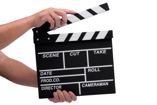 Close-up of hand holding movie clapperboard isolated on white background.