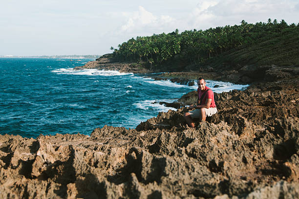 Hispanic man hiking during a vacation at Cerro Gordo beach in Vega Alta, Puerto Rico.