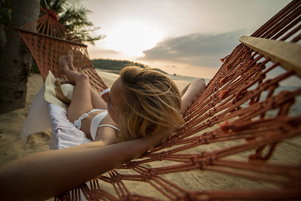 istock Young woman enjoying sunset from hammock 465396670