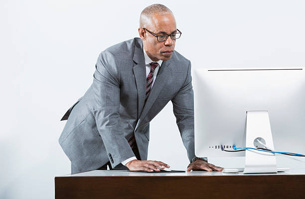 istock African American businessman standing at desk, using computer 465400603