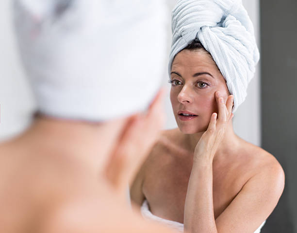 istock Middle aged woman looking at herself in the mirror 465404581