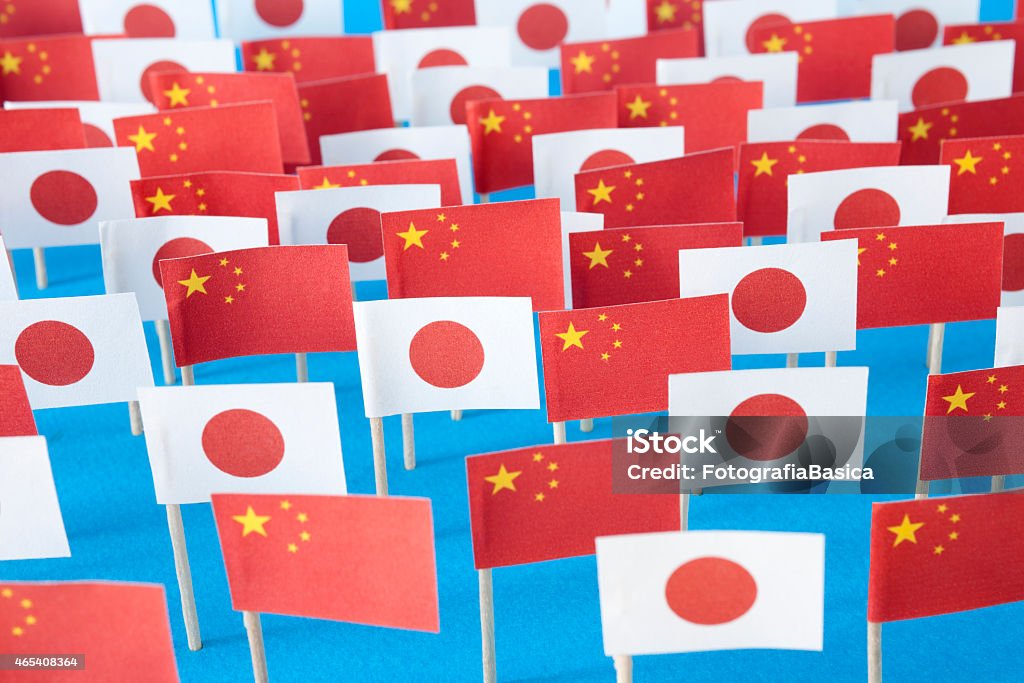 Chinese and japanese flags Lots of paper made chinese and japanese flags over blue background 2015 Stock Photo