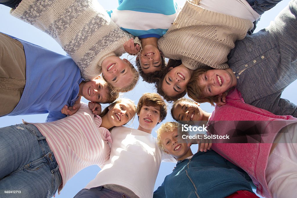 Heads In Group of teenagers with heads together, smiling. 14-15 Years Stock Photo
