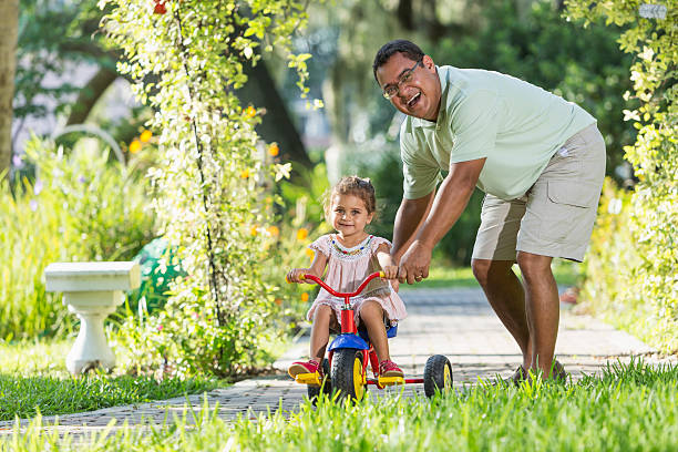 istock Little girl riding tricycle with daddy 465413069