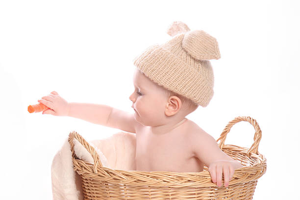 istock Cute bunny boy sitting in basket sharing carrot 465416047
