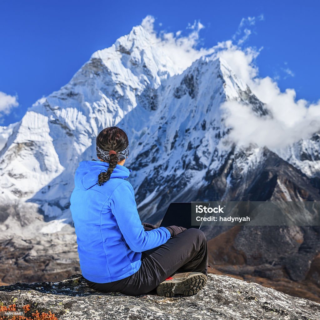 Donna utilizzando il computer portatile nel Parco Nazionale del monte Everest, Nepal - Foto stock royalty-free di 20-24 anni