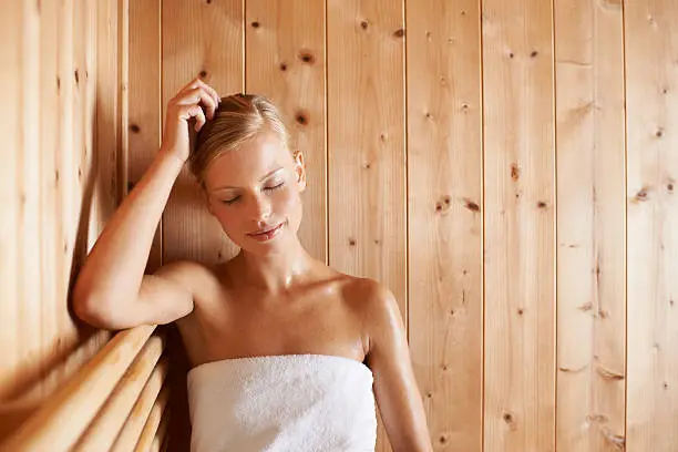 A gorgeous blond woman relaxing in a sauna
