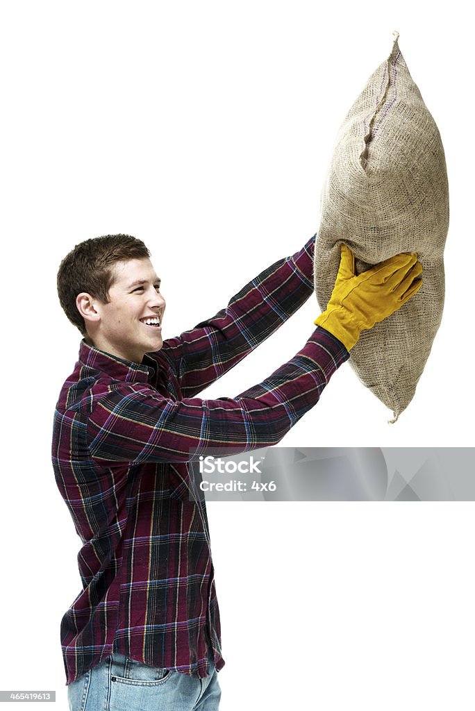 Side view of farmer holding burlap sack Side view of farmer holding burlap sackhttp://www.twodozendesign.info/i/1.png 20-29 Years Stock Photo