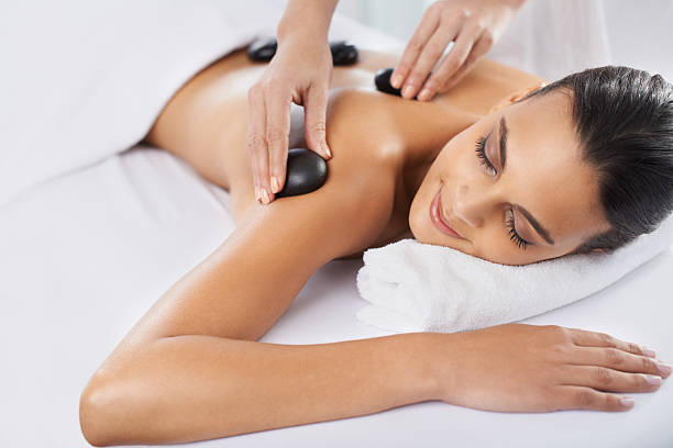 Targeting that muscle tension A young woman having hot stone therapy hot stone massage stock pictures, royalty-free photos & images