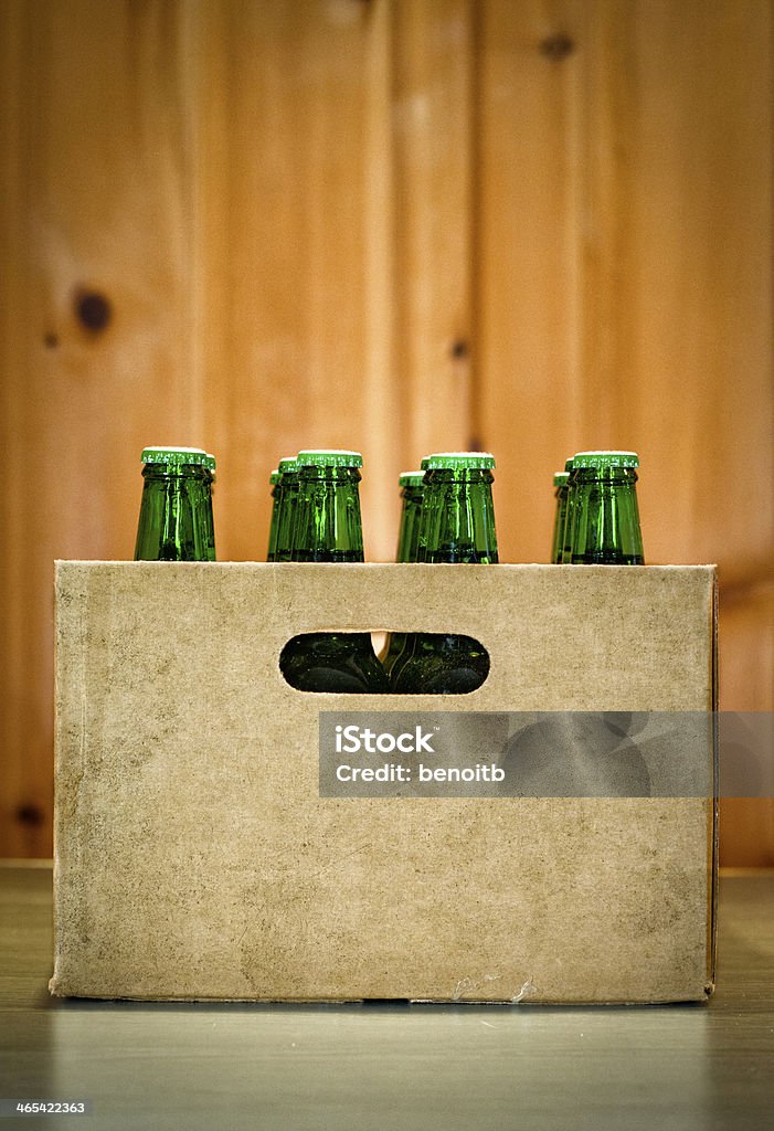 A case of beer bottles with a wood wall in the background Case of beer Beer - Alcohol Stock Photo