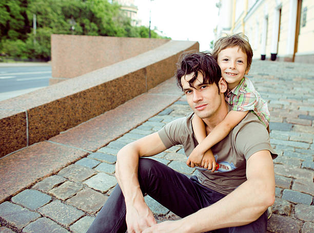 istock little son with father in city hagging and smiling 465425608