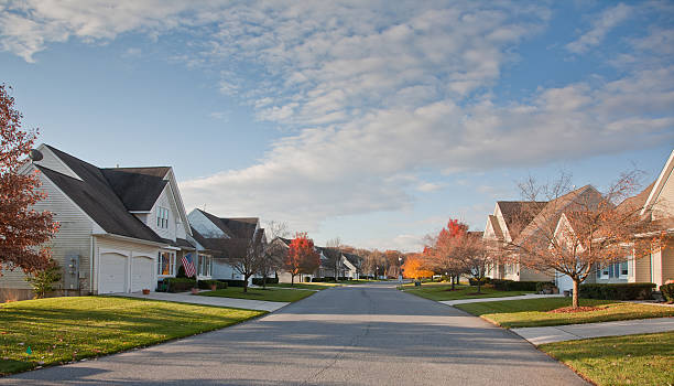 Suburban Street with Uniform Residential Housing Repetitive Community Housing on a Manicured Suburban Street district stock pictures, royalty-free photos & images