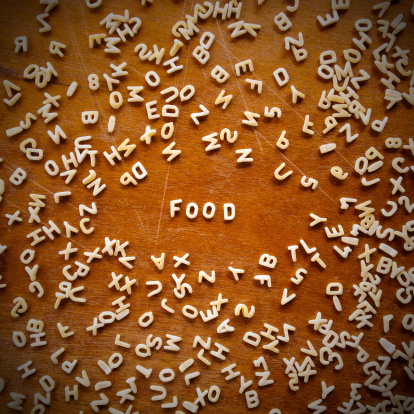 The word FOOD written with soup letters over wooden surface