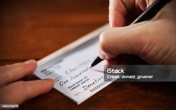 Close Up View Of Hand Writing A Donation Check Stock Photo - Download Image Now - Charitable Donation, Donation Box, Currency