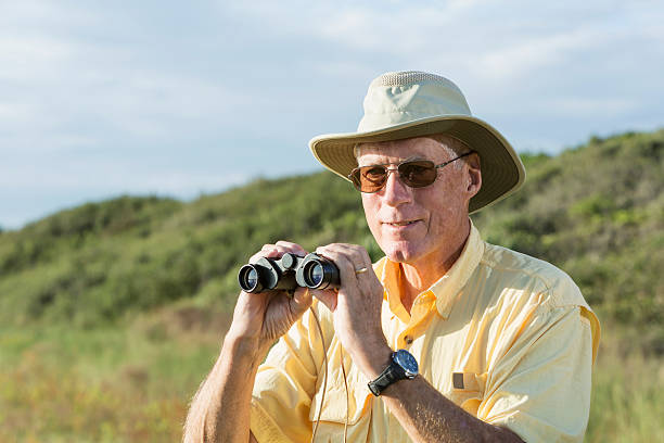 istock Man on safari holding pair of binoculars 465426671