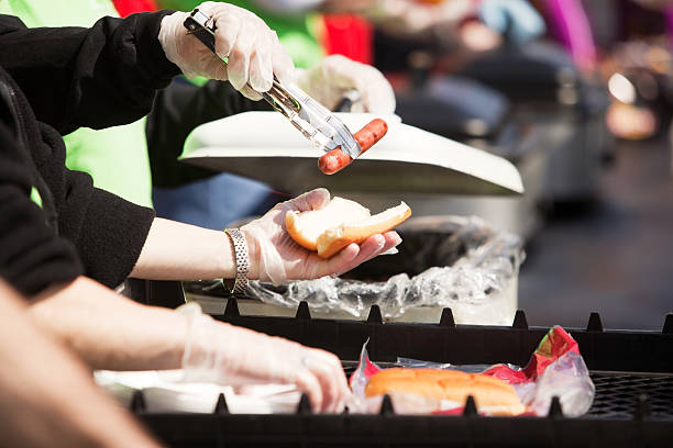 istock Tailgate or Picnic Buffet, Hotdog Placing on Bun 465426861