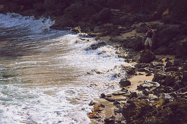 Hispanic man hiking and taking a picture with his smart phone at Cerro Gordo beach  located in Vega Alta, Puerto Rico