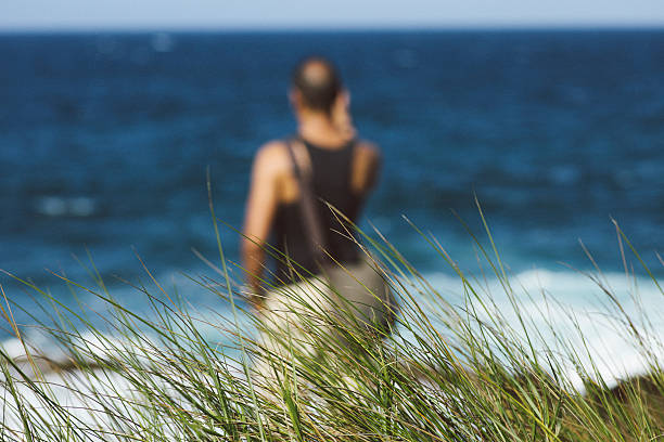 Hispanic man hiking and taking a picture with his smart phone at Cerro Gordo beach  located in Vega Alta, Puerto Rico