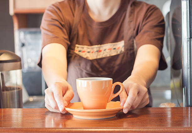 istock Barista offering orange cup of coffee 465432158
