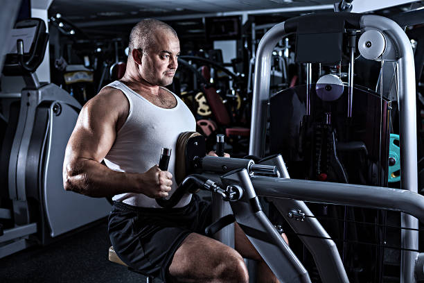 człowiek robi treningu z rozwijanego mashine - human muscle men weights picking up zdjęcia i obrazy z banku zdjęć