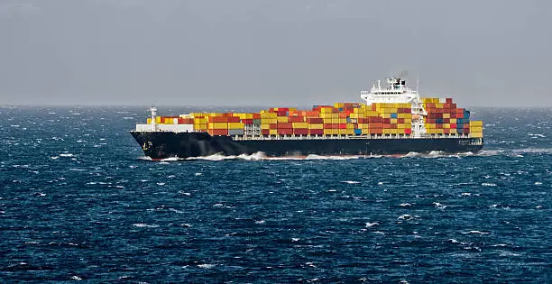 Container freighter ship sailing in stormy ocean