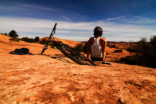 Young girl sitting and relaxing after bike ride in Utah desert.
