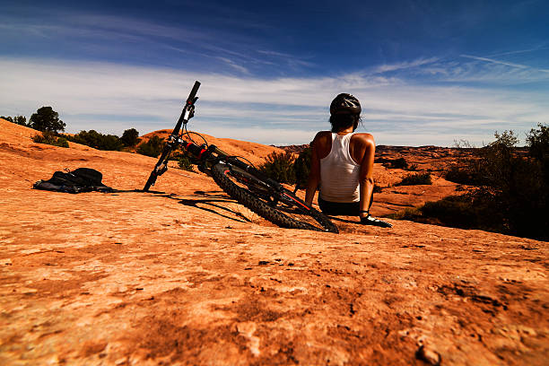 Time to Relax Young girl sitting and relaxing after bike ride in Utah desert. slickrock trail stock pictures, royalty-free photos & images