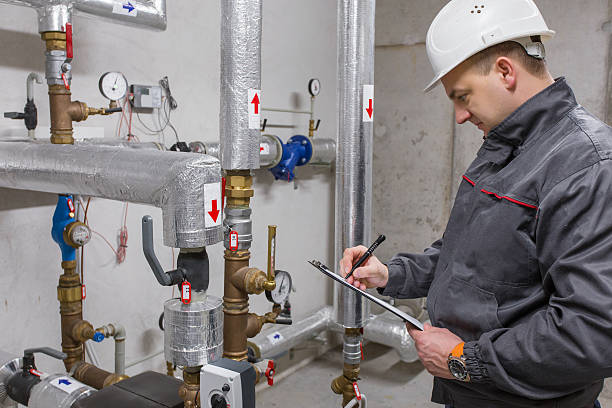 Engineer in boiler room Engineer inspecting heating system in boiler room. meter instrument of measurement photos stock pictures, royalty-free photos & images