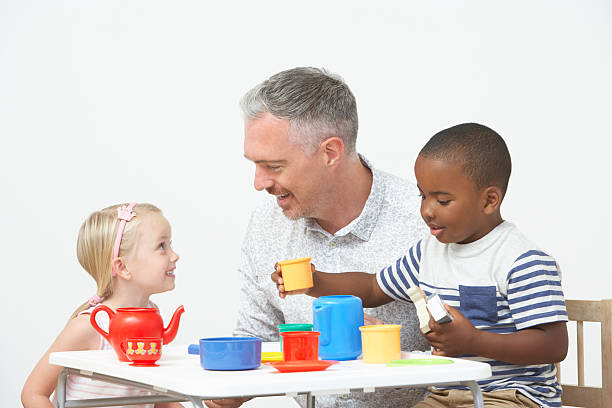 antes de la escuela, niños disfrutando de tea party con maestro - tea party little girls teapot child fotografías e imágenes de stock