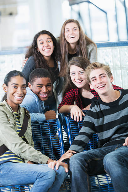 Group of teens Multi-ethnic group of happy teenagers (14-16 years).  Focus on African American boy and girl in red checkered shirt. teenagers only stock pictures, royalty-free photos & images