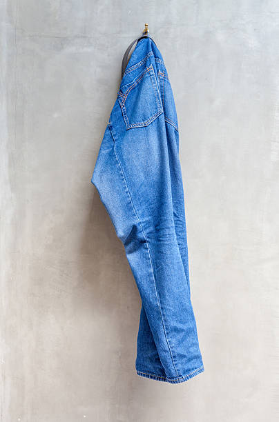 istock Unwashed blue jeans is hanging on the exposed concrete wall. 465451774