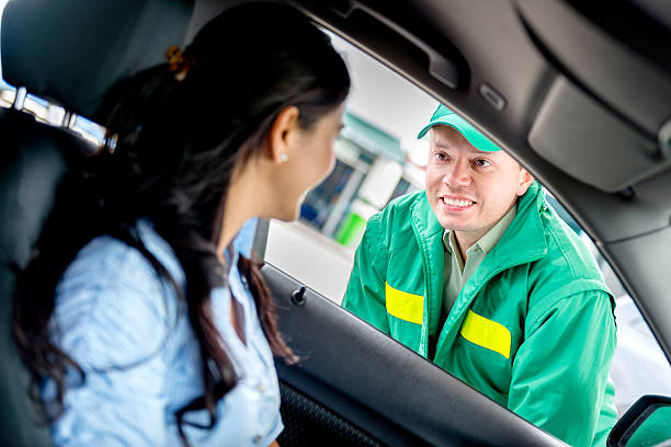 Man helping woman at a gas station Man helping woman with her car at a gas station energy fuel and power generation city urban scene stock pictures, royalty-free photos & images