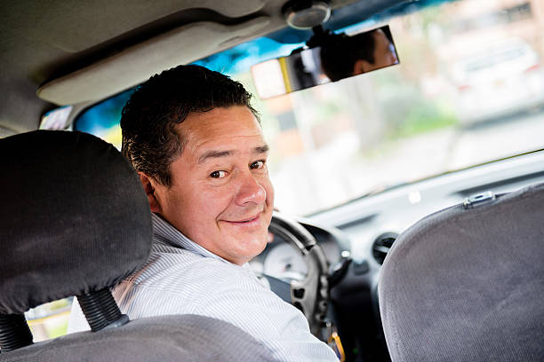 Taxi driver in the car Taxi driver looking happy driving the car taxi driver stock pictures, royalty-free photos & images