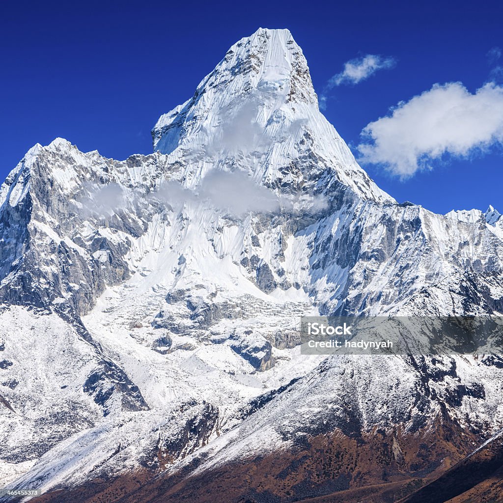 Ama Dablam - Himalaya Range Ama Dablam is a mountain in the Himalaya range of eastern Nepal. The main peak is 6,812  metres (22,349 ft), the lower western peak is 5,563 metres (18,251 ft). Ama Dablam means  "Mother's neclace"; the long ridges on each side like the arms of a mother (ama) protecting  her child, and the hanging glacier thought of as the dablam, the traditional double-pendant  containing pictures of the gods, worn by Sherpa women. For several days, Ama Dablam dominates  the eastern sky for anyone trekking to Mount Everest basecamp.http://bem.2be.pl/IS/nepal_380.jpg Ama Dablam Stock Photo
