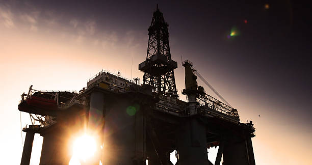 plataforma petrolífera e sol - crane oil well derrick crane floating oil production platform imagens e fotografias de stock