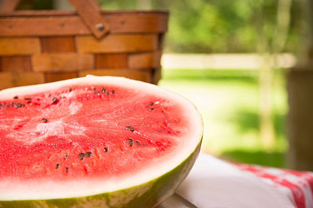 istock Food: Sliced watermelon and picnic basket on table. Outside, summer. 465457245