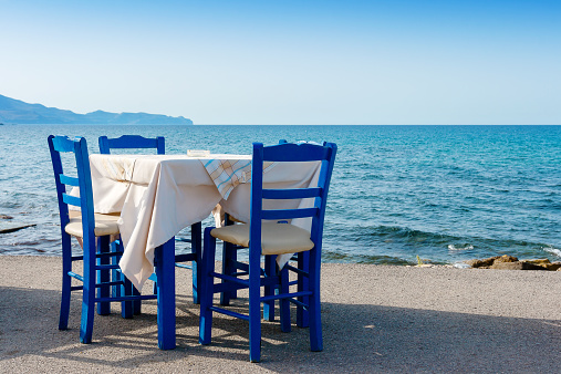 Table and chairs in sidewalk cafe at Kissamos, Crete, Greece
