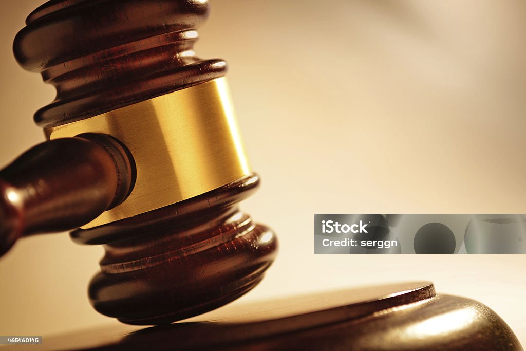 Judge or auctioneers gavel Close up of a wooden judge or auctioneers gavel with a brass band on a wooden base for delivering judgement Book Stock Photo