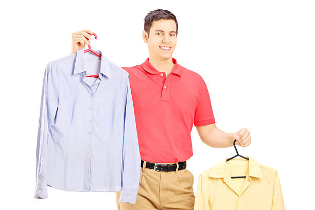 istock Smiling male holding two hangers with shirts 465462709