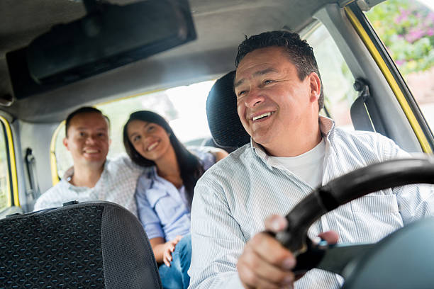 Happy taxi driver Happy taxi driver transporting a couple of passengers taxi driver photos stock pictures, royalty-free photos & images