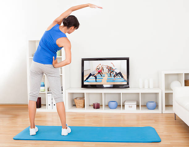 Female Doing Fitness Exercise Female Doing Fitness Exercise In Front Of Television replay photos stock pictures, royalty-free photos & images