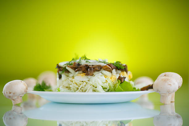 salad with cabbage, eggs and mushrooms on a green background