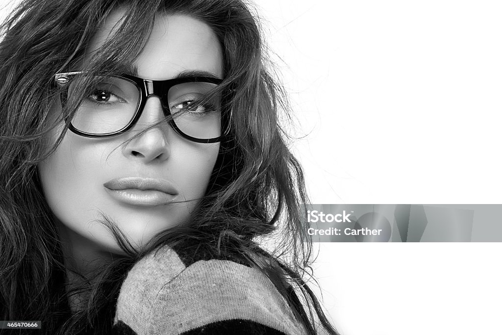 Cool Trendy Eyewear. Beauty Fashion Young Woman in Glasses. Gorgeous brunette fashion model girl with casual hairstyle wearing trendy glasses. Cool trendy eyewear portrait. Closeup in black and white with copy space for text Eyeglasses Stock Photo