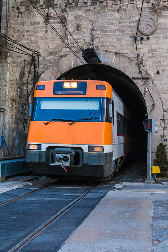 Electric commuter train out of a tunnel in an urban area