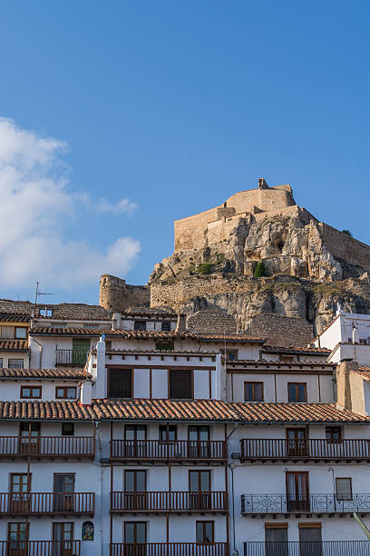 Fort Morella, Valencia. Partial view of an apartment building, with the remains of the fort that defended the city in the background. tarde stock pictures, royalty-free photos & images