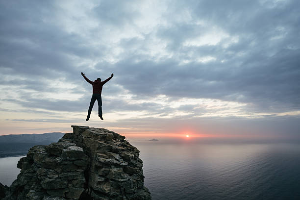 istock Man jump on top of the cliff 465473764