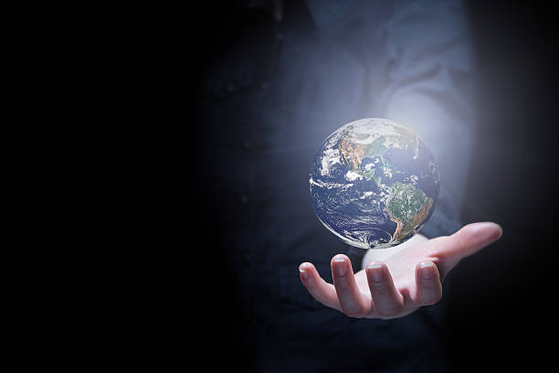 Person holding the earth on their hand Hand of businessman holding earth planet. Elements of this image are furnished by NASA finger spinning globe stock pictures, royalty-free photos & images