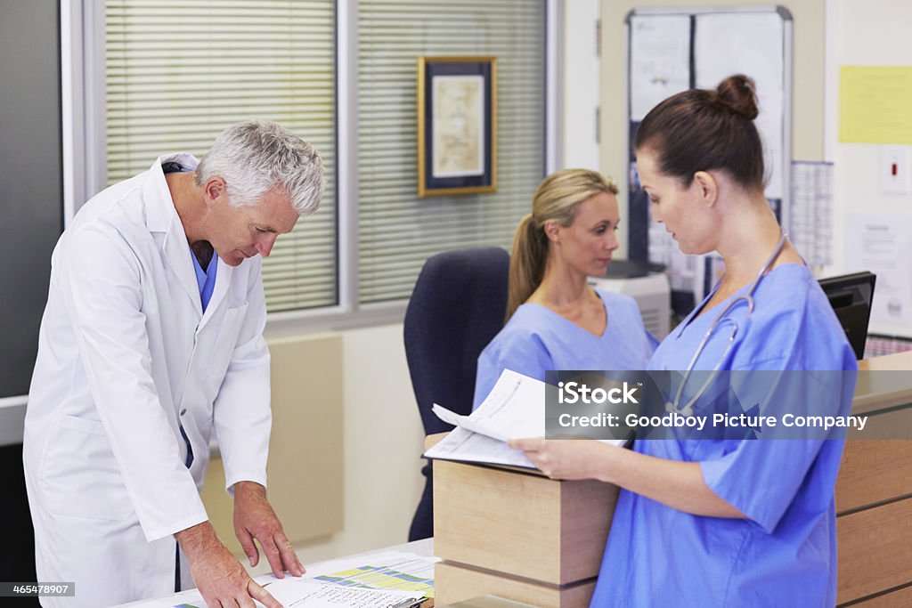 Hospital admin A doctor and two other healthcare workers busy with hospital administration Administrator Stock Photo